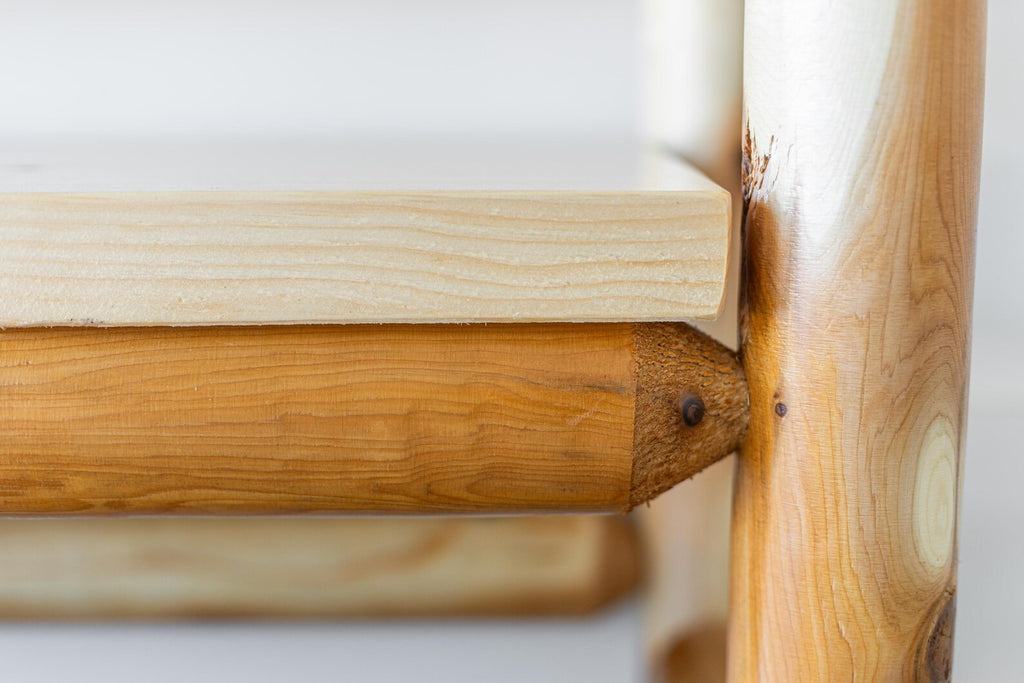 May include: A light-colored wooden shelf supported by horizontal wooden beams shaped like large pencils. The pencil-shaped beams feature a natural wood grain finish with a pointed tip design where they connect to the vertical wooden support post.
