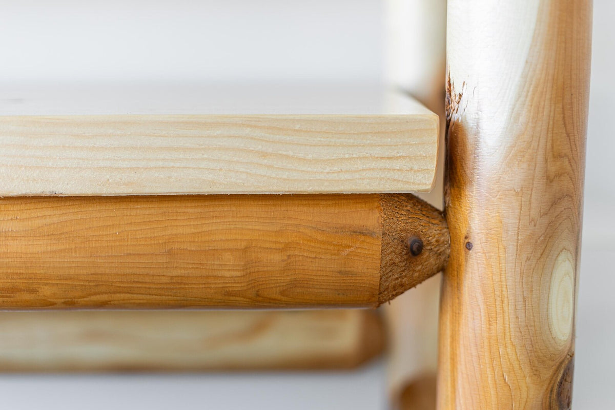 May include: A light-colored wooden shelf supported by horizontal wooden beams shaped like large pencils. The pencil-shaped beams feature a natural wood grain finish with a pointed tip design where they connect to the vertical wooden support post.
