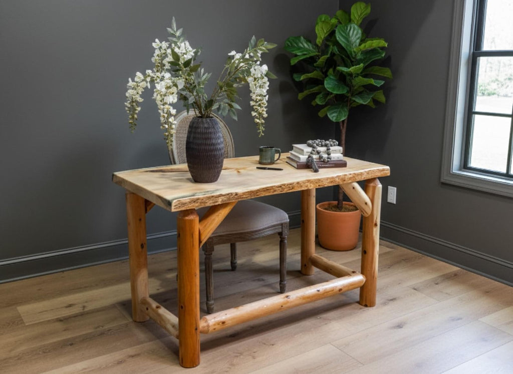 May include: A wooden desk with a natural live edge top and four thick, cylindrical log legs connected by horizontal support beams. The desk features a light-colored wood grain surface and a sturdy, rustic construction with visible joinery.